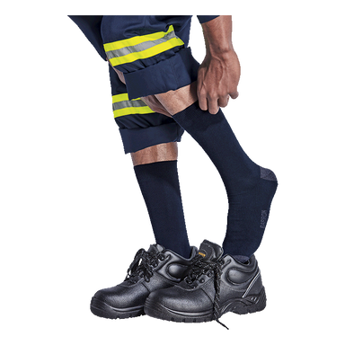 Person wearing black safety shoes, navy socks, and reflective safety pants on a white background