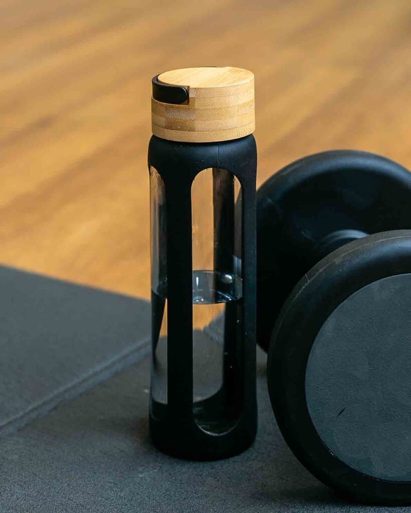 Glass bottle on a surface together with some dumbells